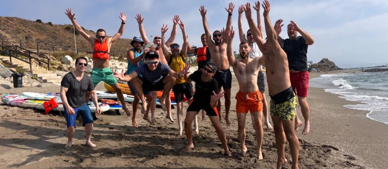 Gruppe av Enonic-ansatte som hopper på en strand.
