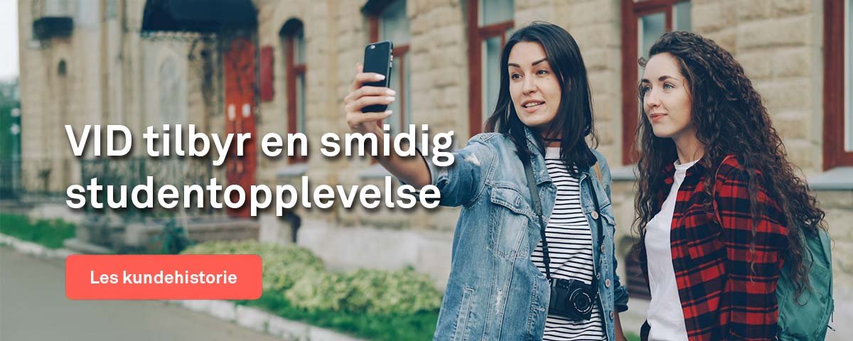 To kvinnelige studenter som ser på en telefon.