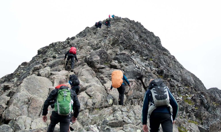 Turgåere nær en steinete fjelltopp.